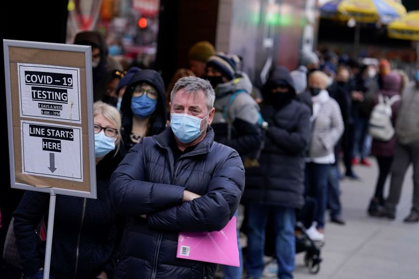 Decenas de personas hacen fila para someterse a una prueba de COVID-19 en Times Square, Nueva York.