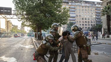 Agentes de polic&iacute;a chilena detienen a un hombre durante una protesta contra el aumento de las tarifas del metro y los autobuses, Santiago, Chile, 18 de octubre de 2019.&nbsp;