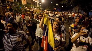  Un grupo de personas celebra la victoria obtenida por la coalición opositora Mesa de Unidad Democrática (MUD) en Caracas. (EFE)  