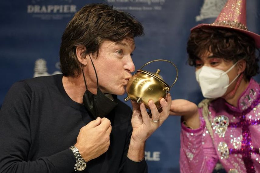 El Hombre del Año 2022 de Hasty Pudding Theatricals de la Universidad de Harvard, el actor Jason Bateman, a la izquierda, besa la caldera de pudín en una conferencia de prensa tras de recibir el premio del grupo teatral en Cambridge, Massachusetts, el jueves 3 de febrero de 2022.&nbsp;