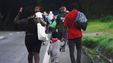 Migrantes haitianos caminan por la carretera en Huixtla, estado de Chiapas, México, la madrugada del jueves 2 de septiembre de 2021 en su viaje hacia EEUU.