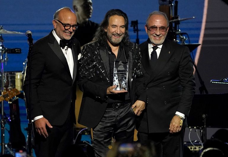 Manuel Abud, director general de la Academia Latina de la Grabación, y Emilio Estefan entregan a Marco Antonio Solís el premio a la Persona del Año en la gala en su honor en la Arena Mandalay Bay Michelob Ultra el 16 de noviembre de 2022 en Las Vegas.