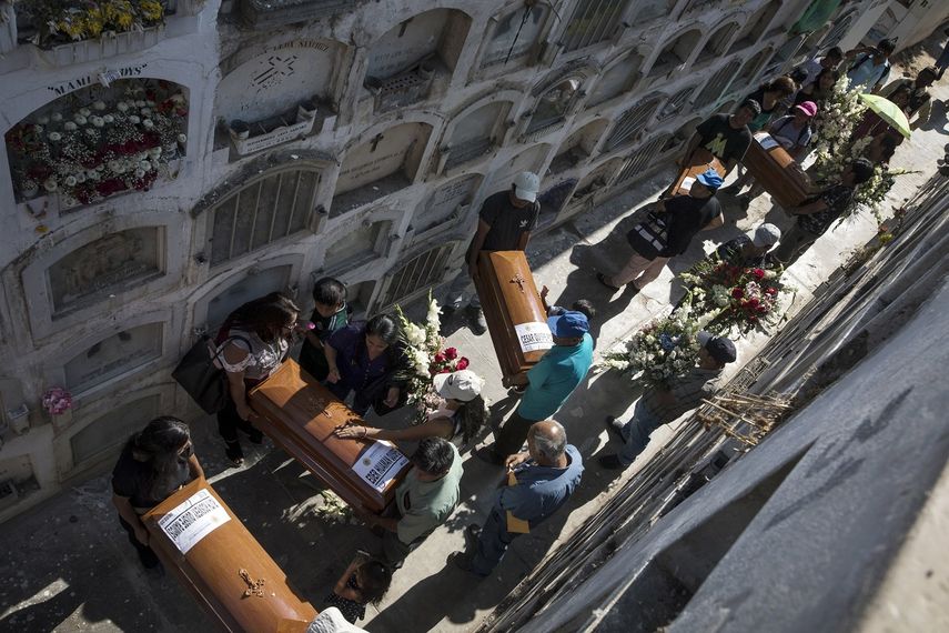 En esta foto del 7 de febrero de 2020, amigos y familiares de Carmen Quispe cargan ataúdes que contienen los restos de cinco familiares que murieron en 1991, durante un brote de cólera, mientras eran cautivos de los rebeldes de Sendero Luminoso, en un cementerio en Lima, Perú.&nbsp;