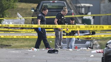 Agentes policiales investigan el lugar de los hechos de uno de los múltiples tiroteos.