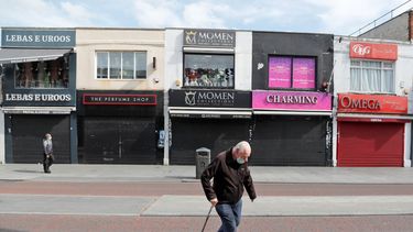 Transe&uacute;ntes con cubrebocas caminan por una calle con tiendas cerradas debido al coronavirus en Londres, el martes 5 de mayo de 2020.&nbsp;