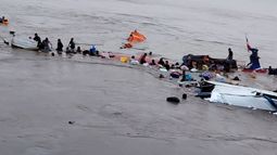 Esta imagen, difundida por el COER (Centro de Operaciones de Emergencia Regional), muestra a personas alrededor de los restos de una embarcación accidentada en el puerto de Iparia, en el departamento de Ucayali, en la selva central de Perú, el 1 de diciembre de 2025.