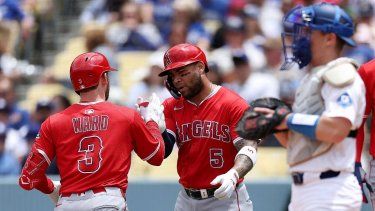 Taylor Ward #3 de los Angelinos de Los Ángeles celebra su jonrón de dos carreras con su compañero Yoán Moncada #5, mientras Will Smith #16 de los Dodgers de Los Ángeles observa durante la primera entrada en el Dodger Stadium el 18 de mayo de 2025 en Los Ángeles, California.&nbsp;