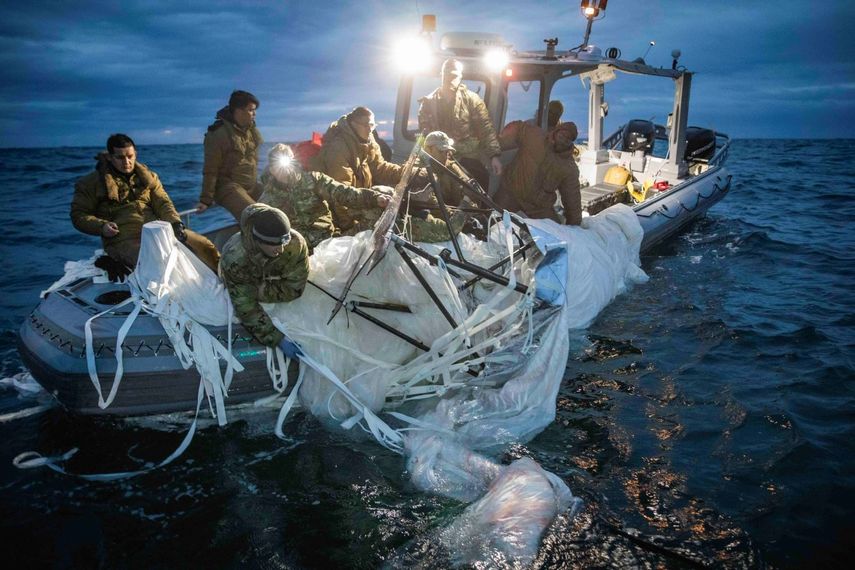 Miembros de la Marina de Estados Unidos recuperan los restos del globo espía de China.