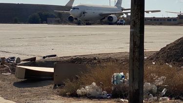 Un avión dañado se encuentra en la pista del aeropuerto de Bagdad que sufrió un ataque de seis cohetes el viernes 28 de enero de 2022. El ataque causó daños pero no víctimas.