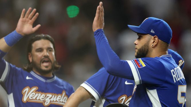 Eduardo Rodríguez #52 de la selección de Venezuela choca las cinco con Eugenio Suárez #7 mientras este abandona el campo tras ser retirado del partido contra la selección de Estados Unidos