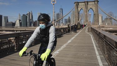 Un ciclista con mascarilla cruza el Puente de Brooklyn, el 16 de marzo de 2020 en Nueva York, en medio de la pandemia por coronavirus.