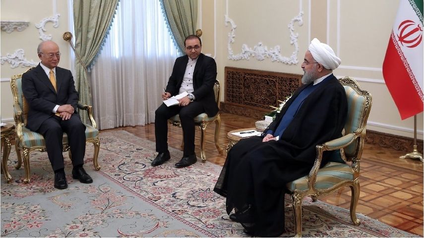 El presidente iraní Hassan Rouhani (der.) habla con el Director General de la Agencia Internacional de Energía Atómica (AIEA) Yukiya Amano (izq.)
