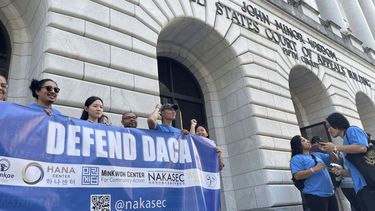 Manifestantes residenciados en los Estados Unidos cuando eran niños sostienen letreros frente al tribunal federal de apelaciones en Nueva Orleans, el jueves 10 de octubre de 2024. 