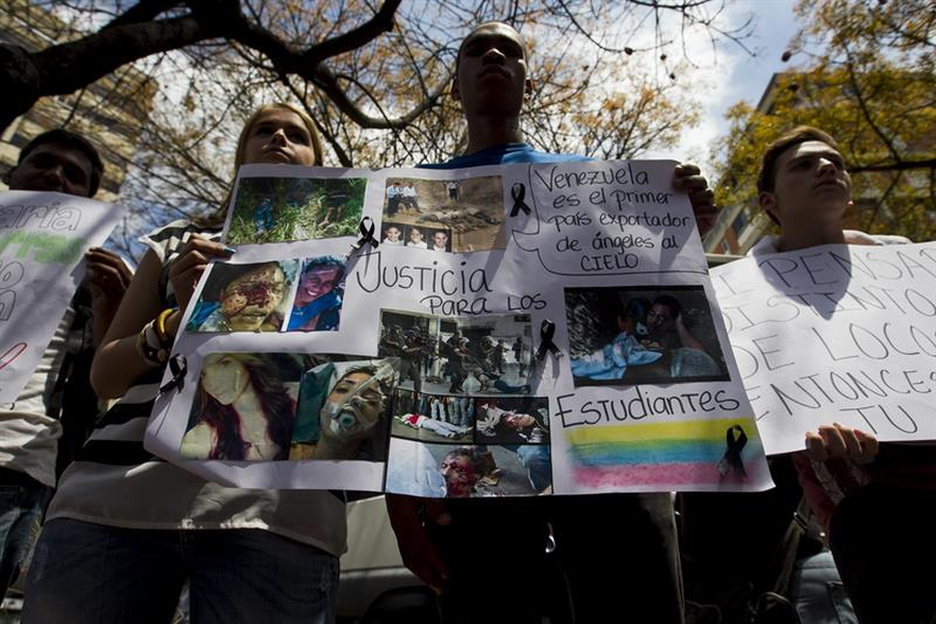 Un grupo de personas sostiene carteles el pasado miércoles, durante una manifestación convocada por un sector de la oposición venezolana frente a la Nunciatura apostólica por la muerte de un adolescente de 14 años, en Caracas. (Foto: EFE)
