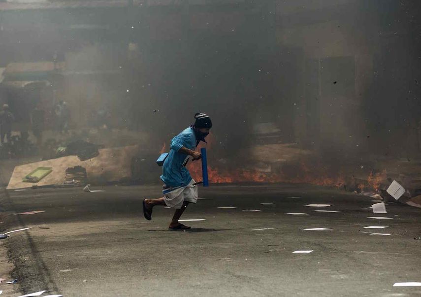 Un joven corre frente a una barricada durante un enfrentamiento con la policía nacional&nbsp; en la ciudad de Masaya (Nicaragua).&nbsp;&nbsp;