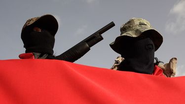 Dos hombres armados y enmascarados son vistos en una celebración en la que participaba Daniel Ortega en Nicaragua. 