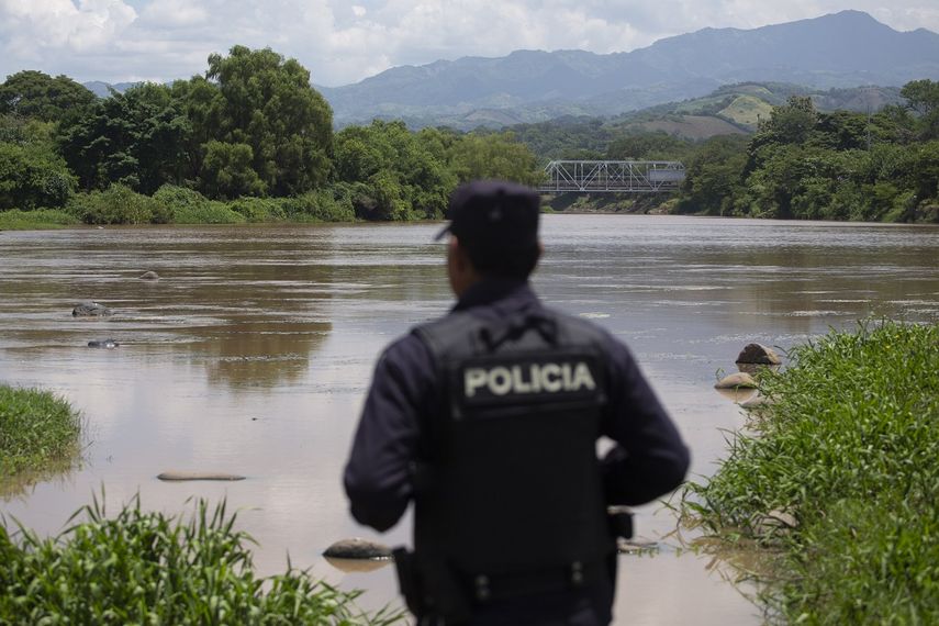 Un agente de la policía nacional salvadoreña observa el río La Paz en la frontera con Guatemala en La Hachadura, El Salvador, es parte de un despliegue de 800 policías y soldados para patrullar los puntos ciegos a lo largo de sus fronteras donde operan contrabandistas de migrantes y delincuentes transnacionales.