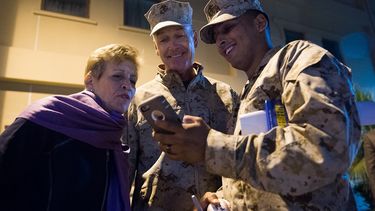 Un marine estadounidense muestra una foto al general de los Marines de Estados Unidos, Joseph F. Dunford Jr., presidente del Estado Mayor Conjunto y su esposa, Ellyn Dunford, en la actividad de apoyo naval de Bahrein, el 7 de diciembre de 2015.&nbsp;