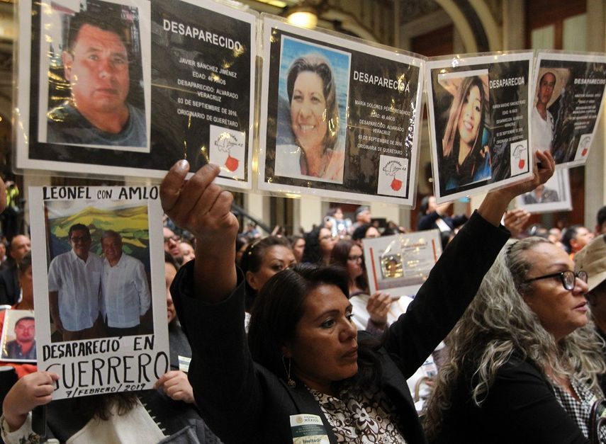 Familiares de personas desaparecidas muestran las fotografías de sus seres queridos durante un acto con el presidente de&nbsp;México, Andrés, Manuel López Obrador, este domingo, en Ciudad de&nbsp;México.