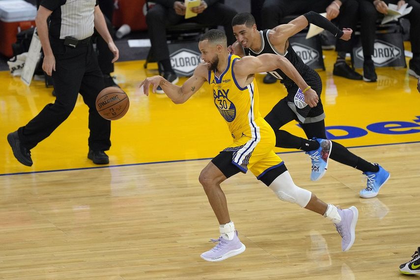 El jugador de los Warriors de Golden State Stephen Curry (con el 30) roba el balón al jugador de los Kings de Sacramento Tyrese Haliburton (con el 0) en la primera mitad de su juego de NBA, el domingo 25 de abril de 2021, en San Francisco.&nbsp;