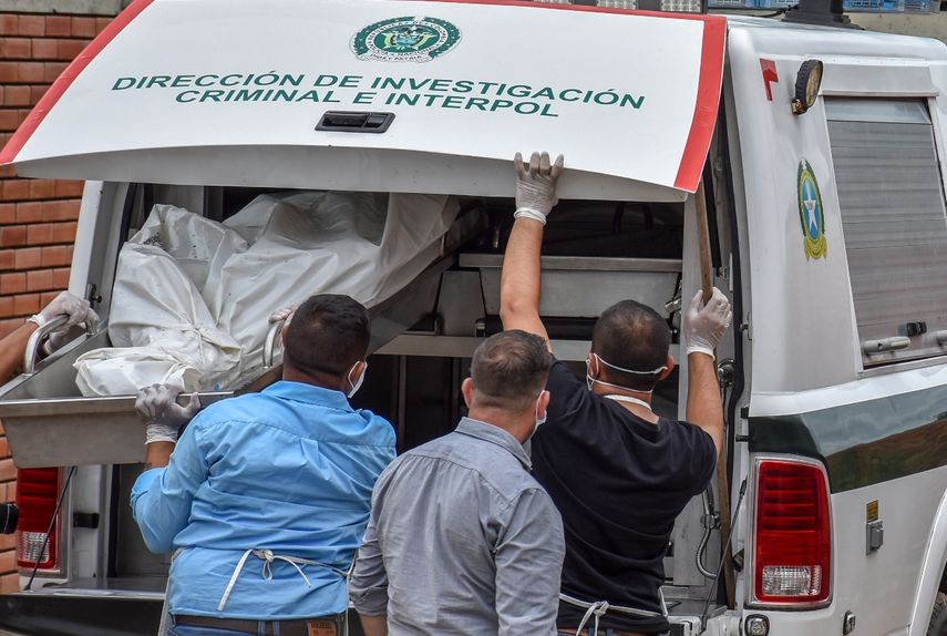 Policías descargan los cadáveres de víctimas de una masacre presuntamente a manos de grupos armados en el municipio colombiano de Arauca, en la morgue de Arauca, cerca de la frontera con Venezuela, el 22 de agosto de 2020.&nbsp;