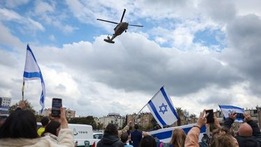 La gente vitorea y ondea banderas israelíes mientras un helicóptero militar que transporta al rehén israelí recién liberado Tal Shoham llega al Hospital Beilinson en el Centro Médico Rabin en Petah Tikva, en el centro de Israel, el 22 de febrero de 2025.