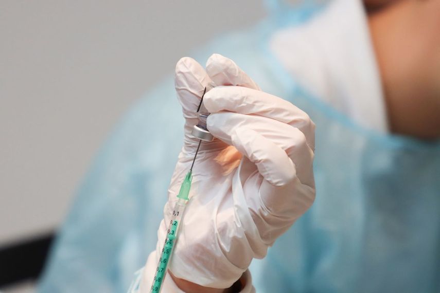 Trabajador de la salud hace los preparativos para a vacunar a una persona.