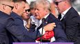 El candidato presidencial republicano y expresidente Donald Trump es ayudado a bajar del escenario en un evento de campaña en Butler, Pensilvania, el sábado 13 de julio de 2024.&nbsp;