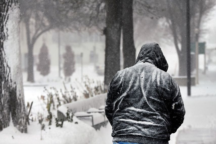 Una persona camina en medio de la tormenta invernal en Bismarck, Dakota del Norte.  
