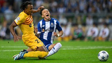 El defensa francés del Barcelona #23 Jules Kounde y el delantero brasileño del FC Porto #11 Pepe caen durante el partido de fútbol del grupo H de la primera ronda de la Liga de Campeones de la UEFA, día 2, entre el FC Porto y el FC Barcelona en el estadio Dragao de Oporto el 4 de octubre de 2023. &nbsp;