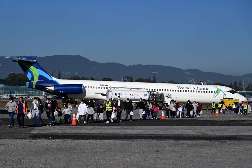 Migrantes guatemaltecos deportados de Estados Unidos caminan por la pista tras llegar a la Base de la Fuerza Aérea Guatemalteca en Ciudad de Guatemala el 27 de diciembre de 2024, durante el último vuelo de deportados del año.