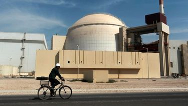 Un trabajador se desplaza en una bicicleta frente al edificio del reactor de la central nuclear de Bushehr, en las afueras de la ciudad sureña de Bushehr, Irán.
