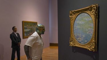 El luchador mexicano CintaDeOro observa una pintura de Claude Monet durante la inauguración de la exposición “Monet. Luces del Impresionismo” en la Ciudad de México el 26 de abril de 2023.