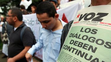 Manifestantes convocados por partidos de izquierda y organizaciones sociales sostienen carteles durante una protesta hoy, miércoles 19 de noviembre de 2014, en Bogotá (Colombia). Los manifestantes exigieron al Gobierno colombiano que mantenga las conve