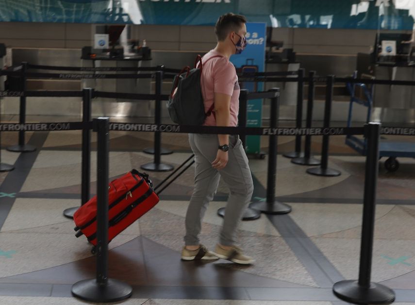 Un viajero solitario se dirije a un mostrador de Frontier Airlines en el aeropuerto internacional de Denver el 22 de julio de 2020, en Denver.&nbsp;