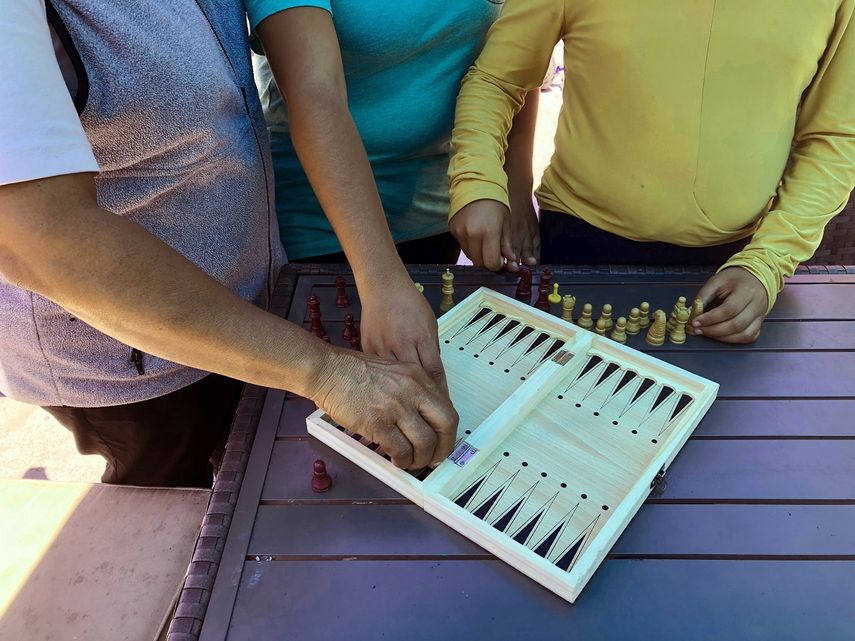 Luz Viviana P&eacute;rez, de 53 a&ntilde;os, monta un tablero de backgammon con sus hijas de 17 y 12 a&ntilde;os en un refugio para migrantes en San Diego.&nbsp;