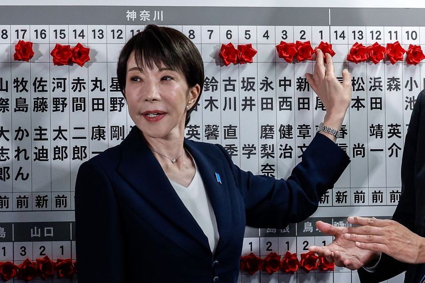 La Primera ministro de Japón y presidenta del Partido Liberal Democrático (PLD), Sanae Takaichi, coloca una rosa de papel roja sobre el nombre de un candidato electo en la sede del PLD durante las elecciones de la Cámara de Representantes en Tokio el 8 de febrero de 2026.