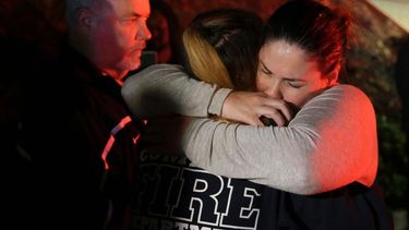 Una mujer que logró huir de los disparos en el Borderline Bar and Grill, abraza a sus familiares en la localidad de Thousand Oaks, California.