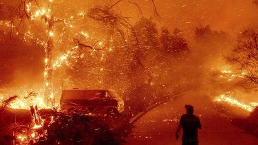 ARCHIVO - Bruce McDougal mira las brasas volar sobre su propiedad durante el incendio Bond en la población de Silverado, en Orange County, California, el 3 de diciembre de 2020