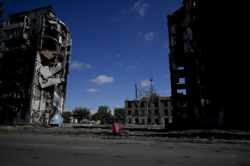 Una mujer monta en bicicleta cerca de edificios destruidos por ataques en Borodyanka, a las afueras de Kiev, Ucrania, el martes 31 de mayo de 2022.&nbsp;