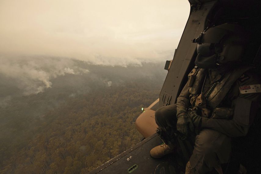 En esta imagen, tomada el 5 de enero de 2020 y proporcionada por el Departamento de Defensa de Australia, un soldado de un helic&oacute;ptero MRH-90 de la marina australiana observa desde el aire los fuegos activos cerca de Cann River, Australia.&nbsp;