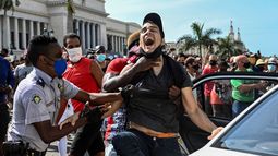 Agentes del régimen en Cuba arrestan a la fuerza a uno de los jóvenes manifestantes.