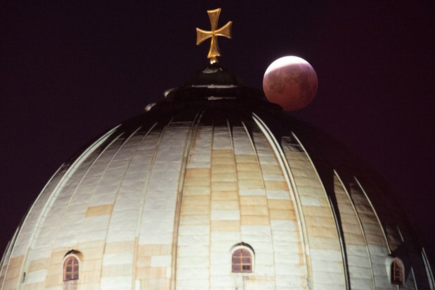 La súper&nbsp;luna&nbsp;de&nbsp;sangre empieza a esconderse tras la cúpula de la iglesia de Santa Isabel en Nuremberg, Alemania.&nbsp;