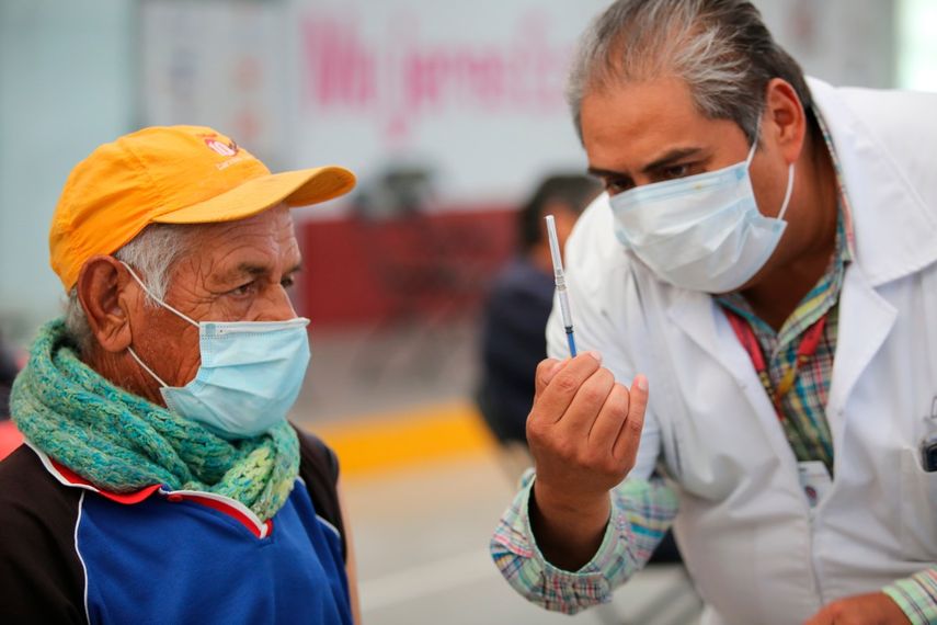 Uno de los enfermeros mexicanos muestra a un anciano una jeringa preparada con una dosis de la vacuna de Sinovac contra el coronavirus antes de aplicársela en el puesto de inoculación instalado en el Centro Cultural y Deportivo Las Américas, en Ecatepec, Estado de México, el sábado 3 de abril de 2021.