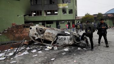 La gente se reúne frente a una estación de policía atacada por partidarios del expresidente Evo Morales en El Alto, en las afueras de La Paz, Bolivia, el martes 12 de noviembre de 2019.