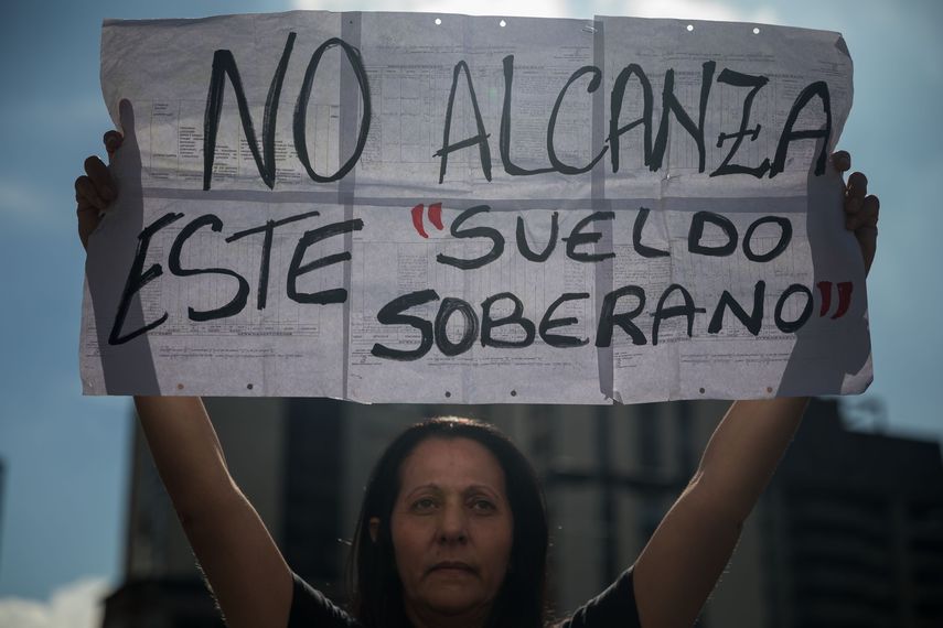 Una mujer sostiene un cartel durante una manifestación de profesores en Caracas, en demanda de mejoras del salario.