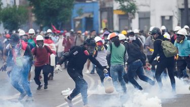 Varios manifestantes antigubernamentales recogen cartuchos de gas lacrimógeno que les lanzó la policía para disolverlos en Lima, Perú, el sábado 28 de enero de 2023.