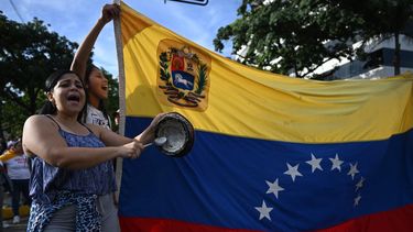 Un manifestante golpea una sartén junto a una bandera venezolana durante una protesta contra la dictadura de Nicolás Maduro en Caracas el 29 de julio de 2024, un día después de las elecciones presidenciales venezolanas.