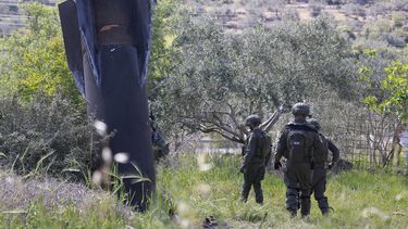 Soldados israelíes inspeccionan los restos de un misil iraní que cayó en la aldea de Hares, en la Cisjordania ocupada por Israel, el 24 de marzo de 2026.