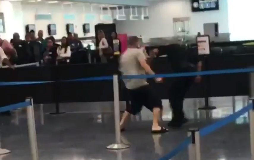 Captura de video que muestra el momento en que un hombre agrede a un oficial en el Aeropuerto Internacional de Miami.